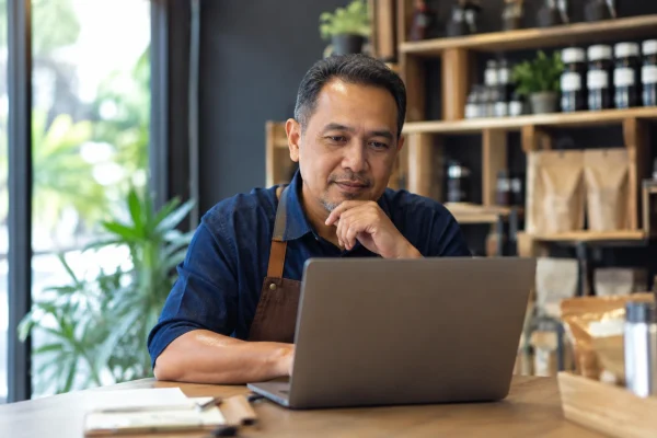 Pemilik SME Malaysia menggunakan laptop untuk mengurus website perniagaan
